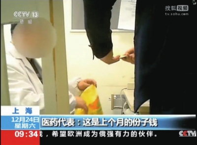 医药代表将装有回扣的信封递给医生。