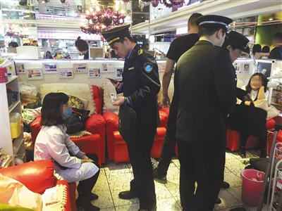 　　昨日，崇文门搜秀三楼美甲区一美甲店，执法人员正在讯问身穿白大褂的刘某，并在现场检查。 新京报记者 大路 摄