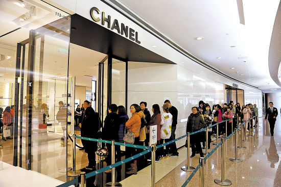 2015年香奈儿内地门店大降价，掀起顾客抢货潮。图为上海恒隆广场人们排队等待进店