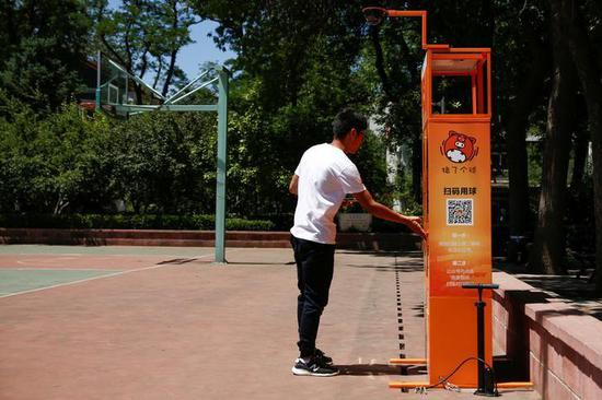 2017年5月24日，中国北京，北京语言大学校园里球场边租借篮球的机器。