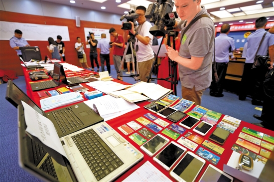 　　10日，警方展示在“飓风23号”收网行动中缴获的电脑、手机、银行卡等涉案物品 羊城晚报记者 黄巍俊 摄