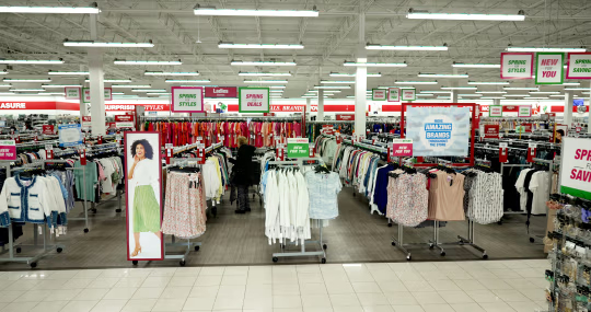 伯灵顿商店内景，可见服装货架及 “春季款式”“春季特惠” 标识。