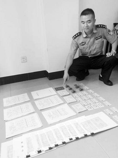 6月21日，警方现场展示犯罪嫌疑人伪造的户口簿和身份证。图/记者宋凯欣