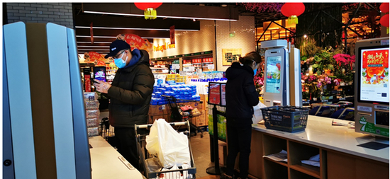 图注：疫情期间顾客通过无接触自助收银机购买生活用品
