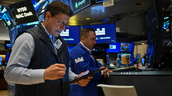 交易员在纽约证券交易所交易大厅工作。