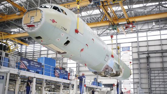 一架空中客车 SE A321 飞机的机身在阿拉巴马州莫比尔的公司总装线设施内被起重机吊起