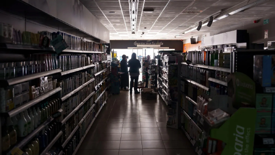 2025 年 4 月 28 日，在一场影响整个伊比利亚半岛和法国南部的大规模停电期间，布尔戈斯一家超市内，员工站在没有灯光的超市里。