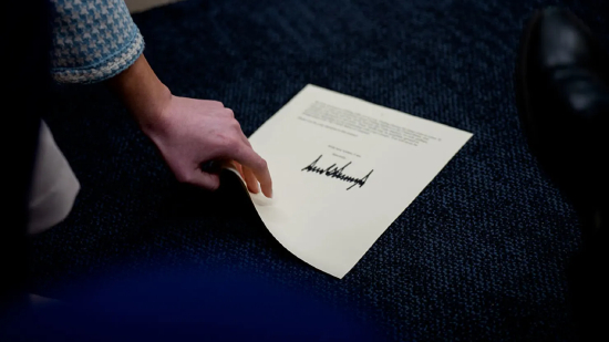 2025 年 7 月 7 日，在华盛顿特区白宫布雷迪新闻发布厅的每日新闻发布会上，一名助手捡起一页特朗普总统写给日本和韩国的信函，信中宣布将于 8 月 1 日起征收 25% 的关祱。