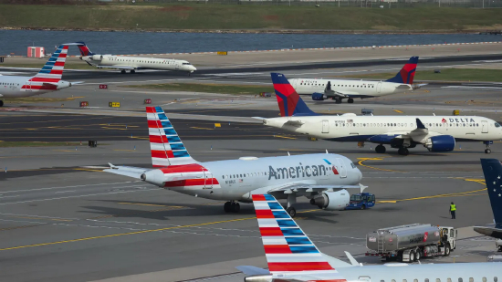 2025 年 11 月 7 日，美国纽约皇后区拉瓜迪亚机场，美国航空与达美航空的飞机停靠在停机坪。美国史上最长政府停摆打乱航空出行秩序，全美航司纷纷取消后续航班，数千名旅客被迫调整出行计划。