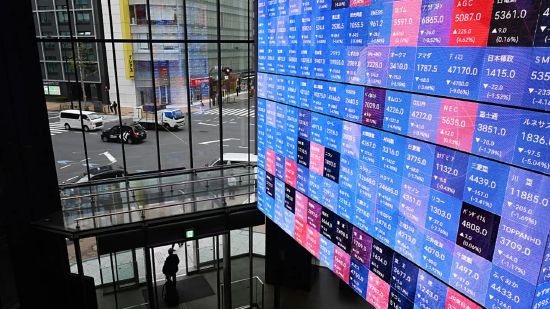 东京证券交易所内，报价板显示日经 225 指数行情。