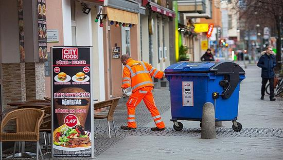 2018年1月5日，德国柏林，一名市政工人拉动一家快餐店门口的垃圾桶。图片来源：视觉中国
