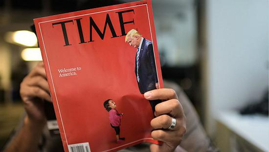 6月22日，美国华盛顿，一名记者阅读以特朗普和移民儿童做封面的《时代》周刊杂志。图片来源：视觉中国