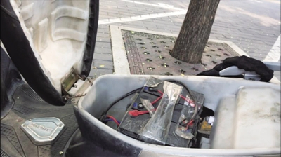 一名骑手向记者展示自己的电动车，车内加装有两块铅酸电池。