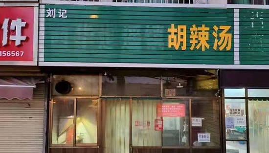 担心侵权，一些商户将“逍遥镇”三字拆掉了。摄影：朱恩民