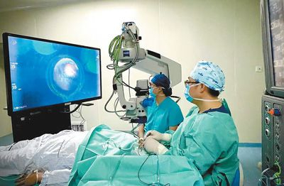 胡博杰（右）和李文博（左）在为患者实施手术。 　　天津医科大学眼科医院提供