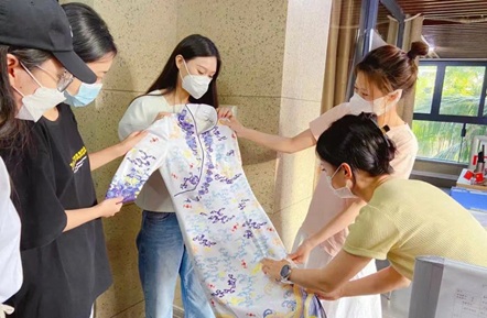  图：员工们正在仔细端详领到的新制服