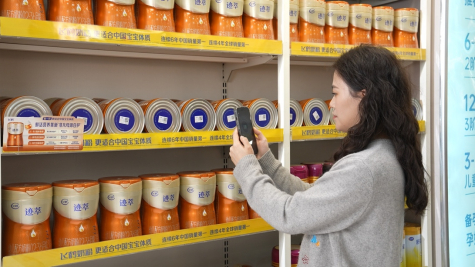 图：消费者扫码体验全球首个奶粉新鲜原料溯源系统