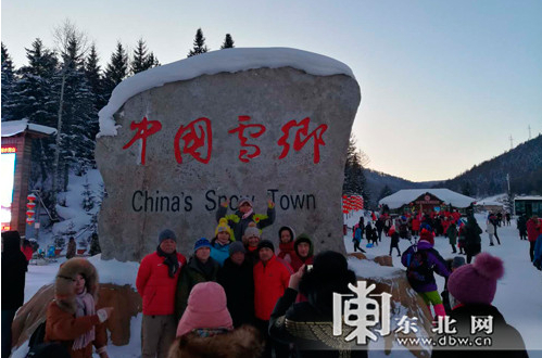 抵达雪乡的游客在“中国雪乡”石碑前合影，见证到此一游。