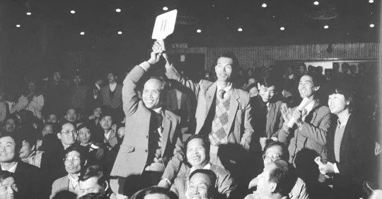 骆锦星（左）举起的11号牌。