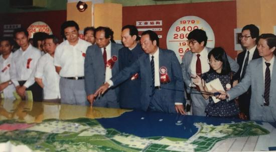　　1985年，深圳经济特区工业产品陈列馆开幕，市领导梁湘、李灏、周溪舞、邹尔康（右五至右八）等在现场参观。