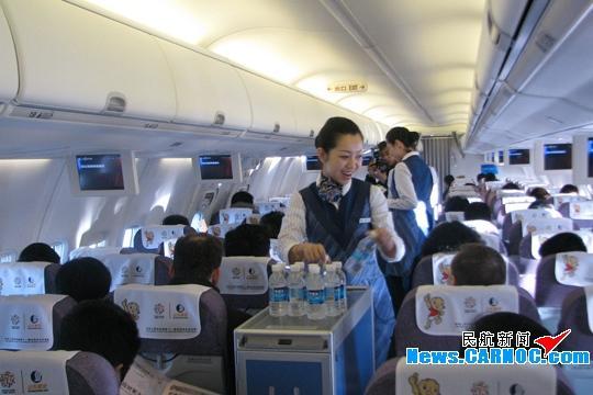 山航乘务员在客舱为首航旅客提供饮用水服务