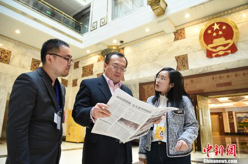 　　资料图：2018年3月10日，全国人大代表，浙江省纪委书记、浙江省监察委员会主任刘建超（中）翻阅《中国新闻》。 中新社记者 侯宇 摄