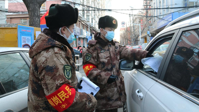 （图为南岗区民兵在防疫执勤点检查登记。郭海冰摄）