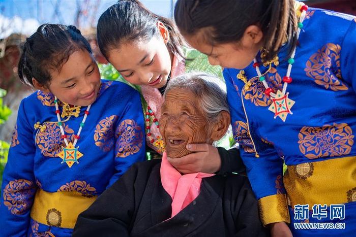 109岁的索朗卓玛和曾孙女旦增宗吉（右一）、旦增央吉（左一）、丹增曲吉在自家的院子里（3月24日摄）。新华社记者 普布扎西 摄