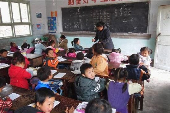 图说：这个正在给学前班孩子上课的老师，当了几十年的民办老师，在退休之前终于要转正了。