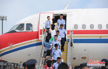 　　“11·29”特大跨国跨两岸电信诈骗犯罪嫌疑人在我国公安民警的押解下走下旋梯。人民网记者 于凯摄