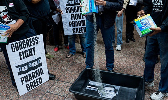 艾滋病抗议者在图灵公司所在大楼前，向史克雷利的画像倾倒猫砂以示抗议