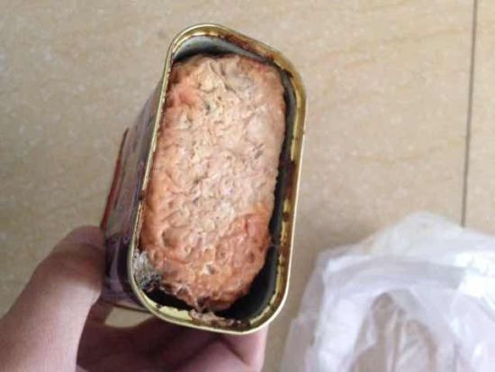 图为批发商何先生提供罐头。（图片来源：中国广播网）