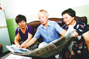 　　叶聪父母(右二、右一)看关于儿子的报道