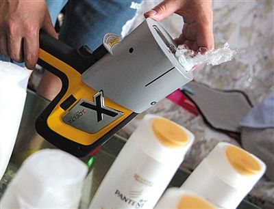 环保组织“自然大学”工作人员检测“高仿”洗发水的重金属含量。