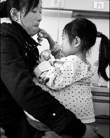 接过爱心人士送来的面包，小星掰下一块先往妈妈嘴里送 摄/记者林晖