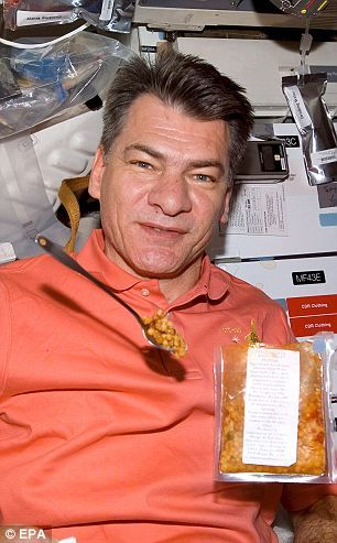 2007年，保罗·内斯帕里在“发现”号航天飞机上与飘浮在空中的他要吃的东西合影留念