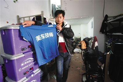 11月2日，位于南沙窝桥附近的我爱洗车站点内，一位员工展示曾经的工作服。