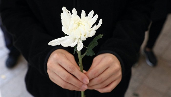 　　10月31日，韩国首尔，市政厅前，一名女子手持鲜花，在梨泰院踩踏事件遇难者的纪念祭坛前献礼。图片来源：视觉中国