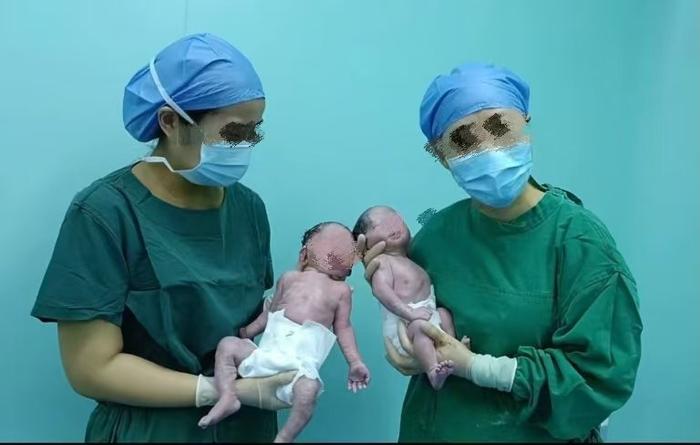  邵医生（右一）与同事抱着龙凤胎新生儿。