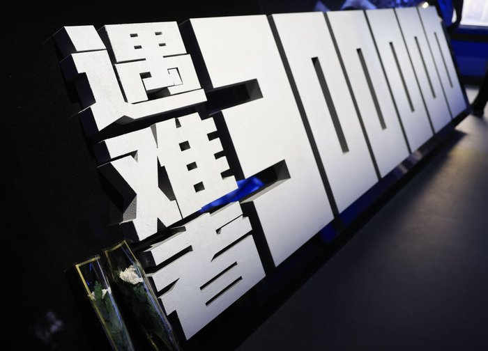 2025年7月8日，参观者在位于北京的中国人民抗日战争纪念馆参观《为了民族解放与世界和平》主题展览时，留下两朵白菊纪念南京大屠杀遇难者。新华社记者 张晨霖 摄