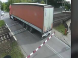 波兰一卡车被困铁路道闸之间，一列车驶来“拦腰”撞上