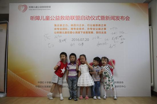 参加演出的听障儿童在签名板前合影