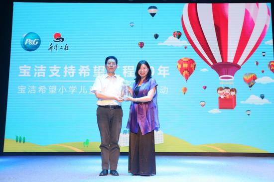 　　中国青少年发展基金会常务副秘书长杨晓禹先生向宝洁中国传播与公关部公司事务组总监梁云女士颁发奖杯