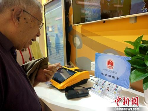 资料图：正在参观社保内容的退休老人。中新网记者李金磊 摄