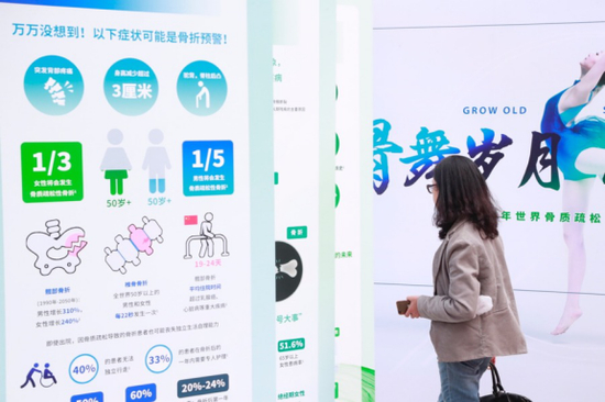 &nbsp;一位正在阅读骨质疏松相关科普知识展架的观众
