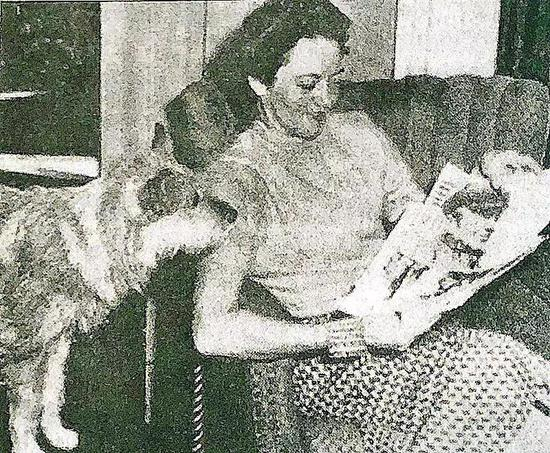 （图为“老爸”的夫人在看他拍摄的照片）