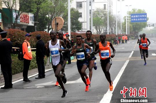 图为参赛的高水平专业马拉松运动员始终跑在队伍前面的第一方阵。　崔佳明 摄