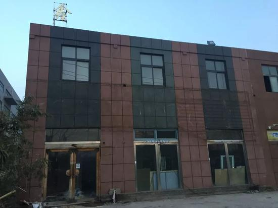 “郑州城管撤梯”事发现场，广告牌只剩一个“鑫”字。新京报记者赵蕾 摄