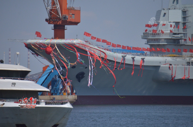 工人检查舰艏的情况:国产航母下水后继续施工