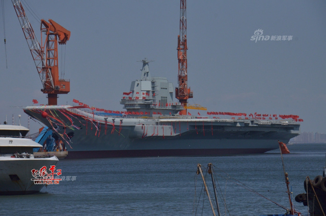 工人检查舰艏的情况:国产航母下水后继续施工